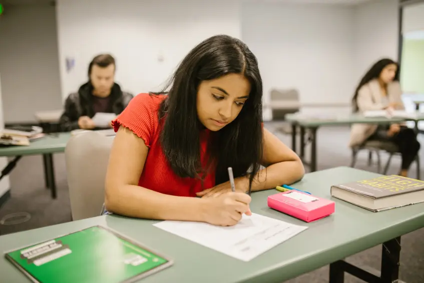 Pakistani female student attending a class and writing notes