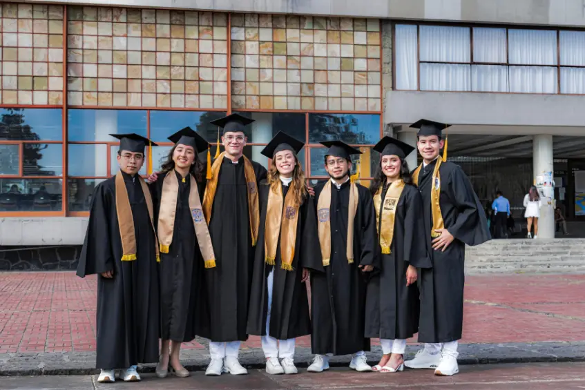 Pakistani students wearing graduation gowns and celebrating their success at a UK university