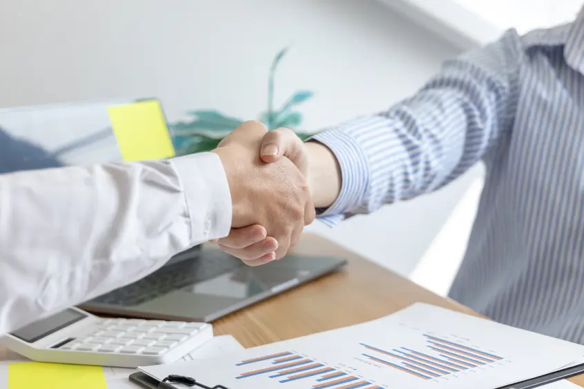 Visa Territory offering free counseling for Pakistani students applying to UK universities. Two men shaking hands.