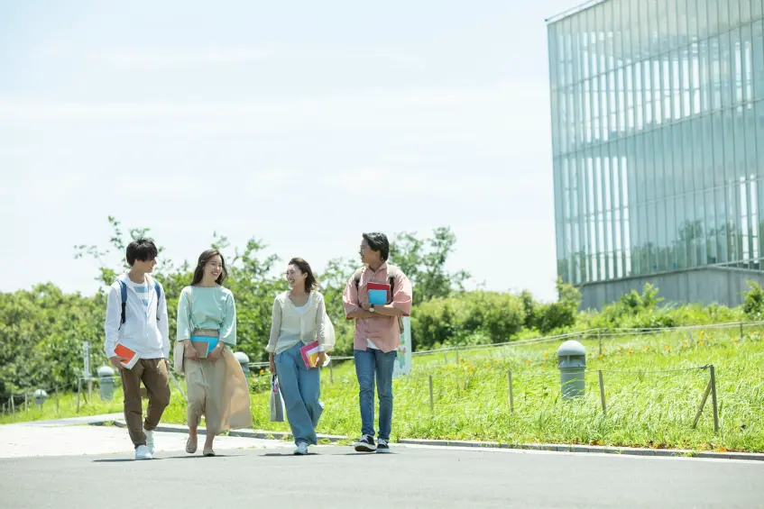 Group of students walking on a UK university campus, representing the study abroad journey with the help of UK study visa consultant.
