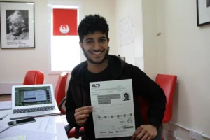 Boy showing IELTS test result with high band score at study and immigration consultant office in Islamabad