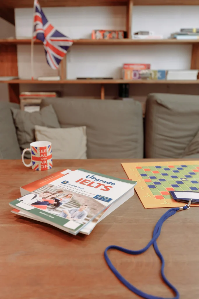 Student preparing for IELTS Life Skills A2 exam with study book and practice materials in a study room